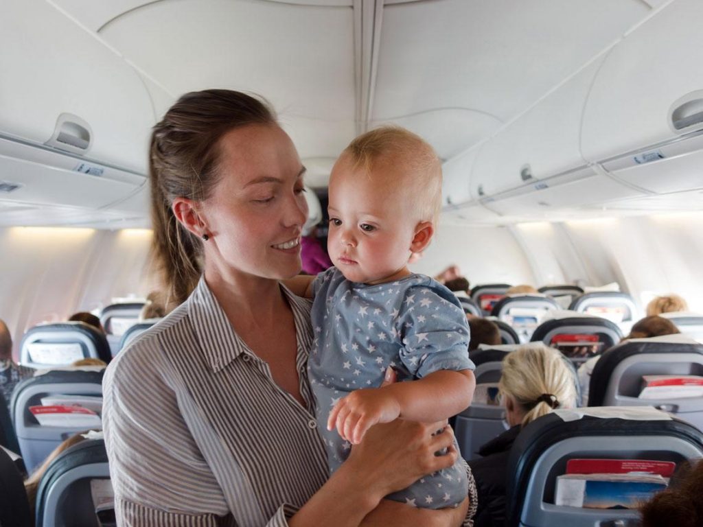Chica con su bebé arriba de un avión
