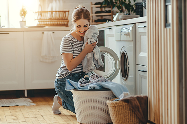 mujer lavando ropa y su colección de lenceria en lavadora