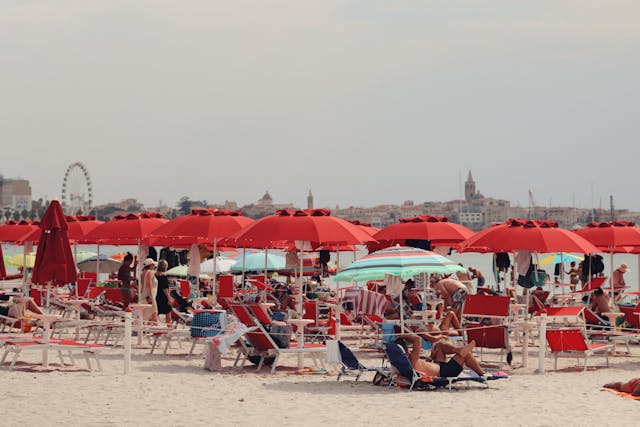 Personas bajo el sol con sombrillas